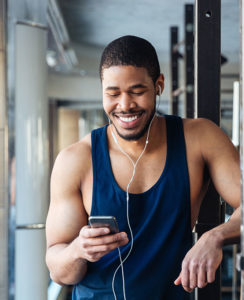 Young black man listening to music while using the fitness center